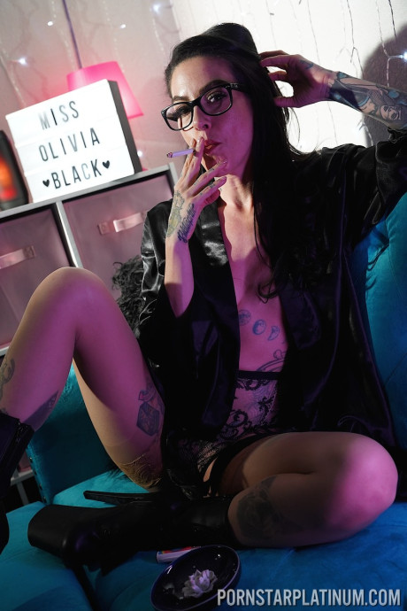 Inked pornstar Olivia black poses in enormous heels and negligee while smoking