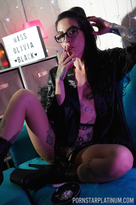 Inked pornstar Olivia black poses in enormous heels and negligee while smoking