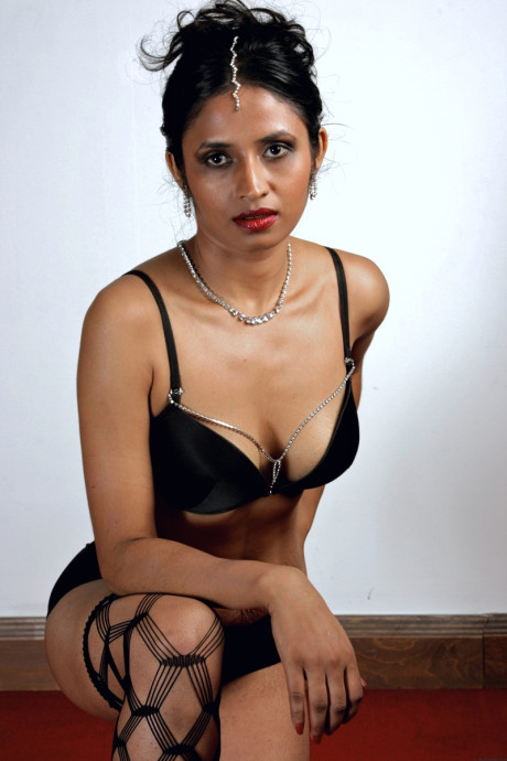 Gorgeous Indian female sheds an overcoat to model in underwear and stockings