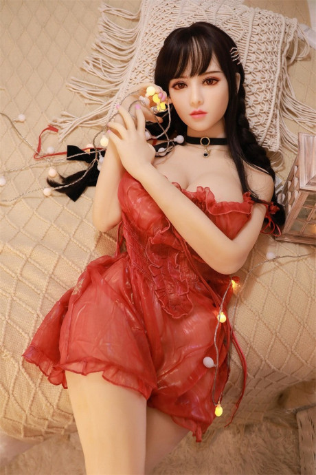 Sex doll with red eyes removes her dress to pose nude in a collar