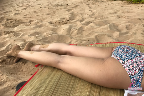 Amateur girl Liza Rowe poses in her pretty bikini on a sandy beach
