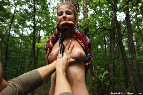 Thin blondy slut girl lady is flogged while tied to a tree in the forest