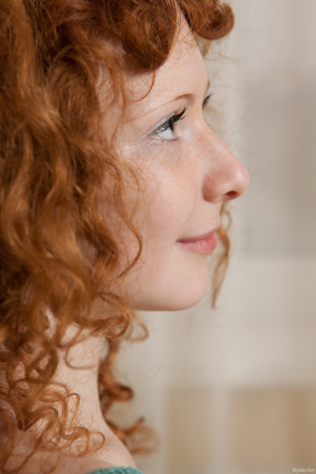 Curly-haired red hair Rochelle exposes her charming body and poses on her bed