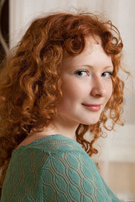 Curly-haired red hair Rochelle exposes her charming body and poses on her bed