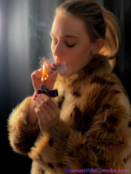 Blondy with a ponytail poses in her fur coat as she smokes a cigarette