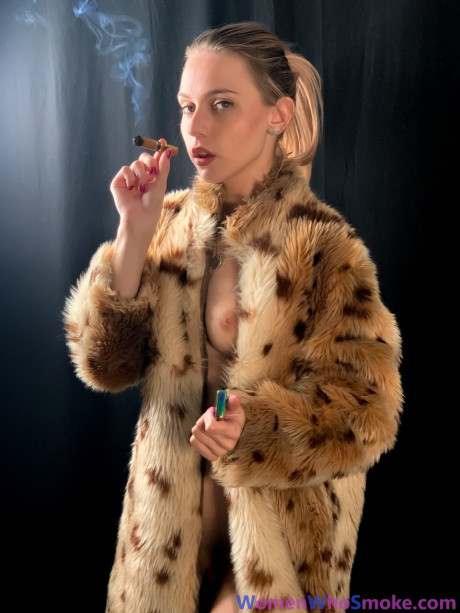 Blondy with a ponytail poses in her fur coat as she smokes a cigarette