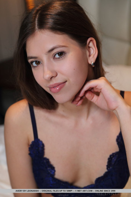 Stunning brunette teen Avery discards her undergarment to go undressed on a bed