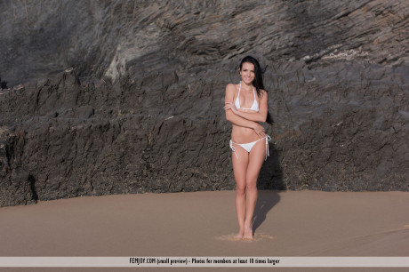 Fresh young brunette Sapphira looses her bikini to pose nude on a pristine beach