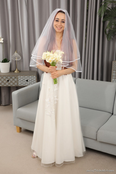 Redheaded bride Tania Aresti goes undressed in a veil along with garters and pantyhose