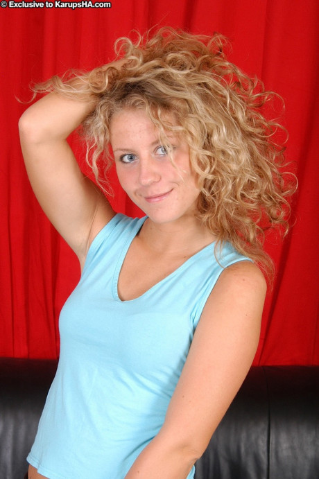 Curly haired blonde Lita exposes her tiny titties and presents her pussy