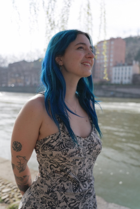 Blue haired inked young Khalamite exposes her magnificent curves and gigantic boobies