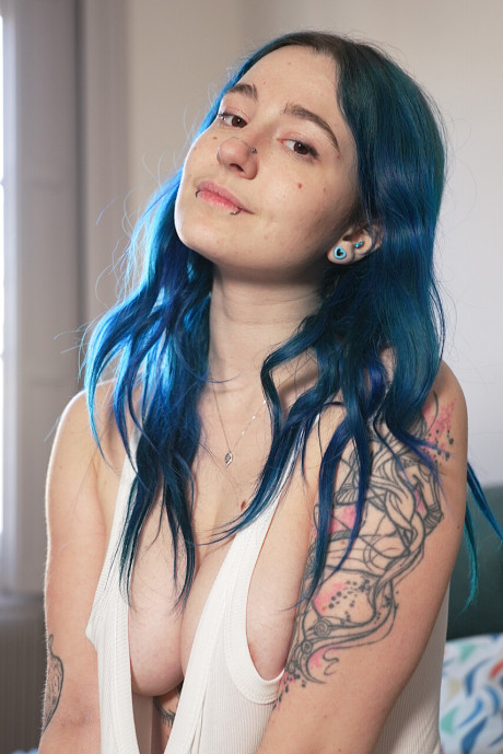 Blue haired inked young Khalamite exposes her magnificent curves and gigantic boobies