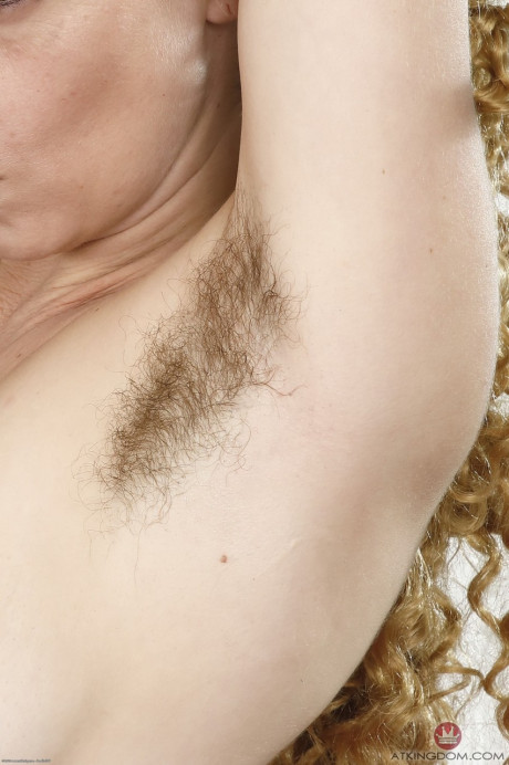 Cougar solo model with curly red hair exposes her unshaven armpits and vagina
