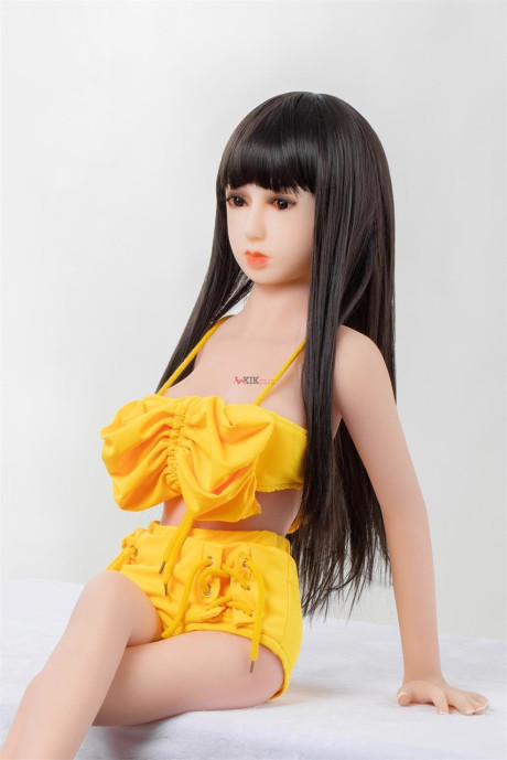 Thin brunette sex doll Carys strips poses naked and in a lovely yellow outfit