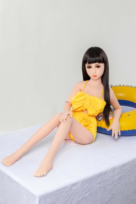 Thin brunette sex doll Carys strips poses naked and in a lovely yellow outfit