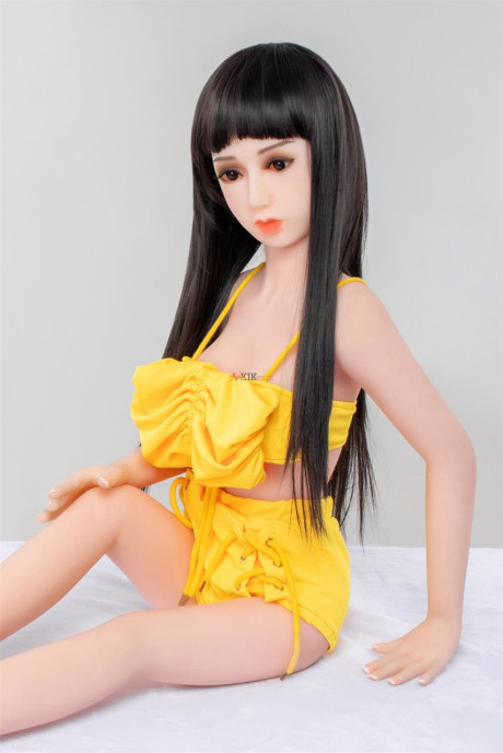 Thin brunette sex doll Carys strips poses naked and in a lovely yellow outfit