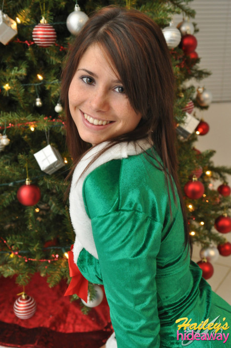 Amateur Xmas elf Hailey lifts her tight skirt to show her sexy butt by the tree