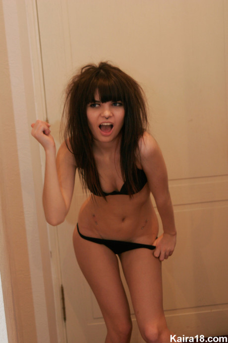 Petite teenie Kaira 18 smokes a cigarette while getting undressed in her bedroom
