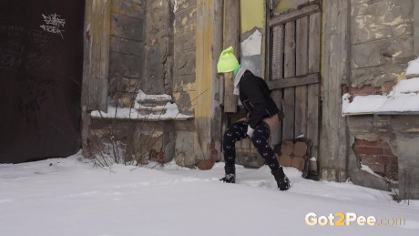 Fine blonde squats in the snow to relieve herself