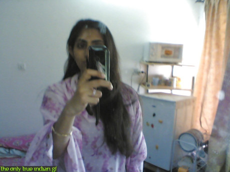 Indian girl girl woman takes selfies in a mirror while wearing a see-through tank top