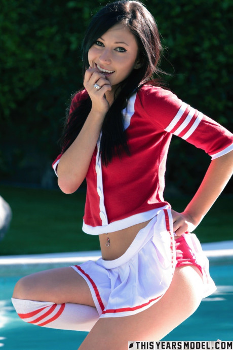 Brunette cheerleader Catie Minx exposes her tight ass near a swimming pool