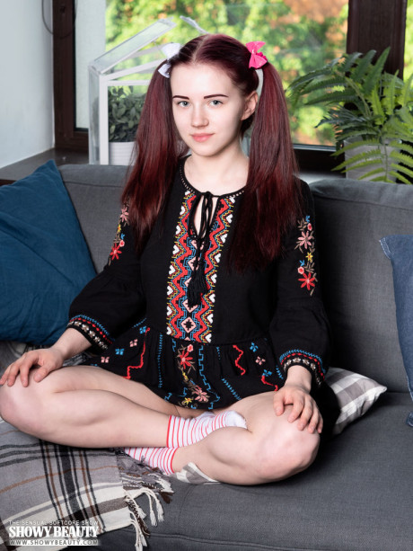 Young teen looking teenie Polina strips to her socks on a sofa in pigtails