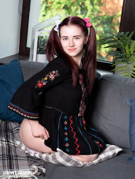 Young teen looking teenie Polina strips to her socks on a sofa in pigtails