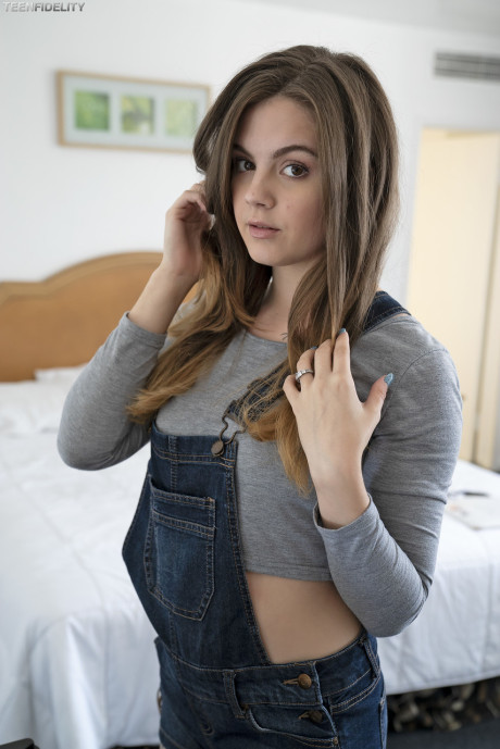 Adorable teen Devon Green pulls off her shorts to show charming ass on the bed