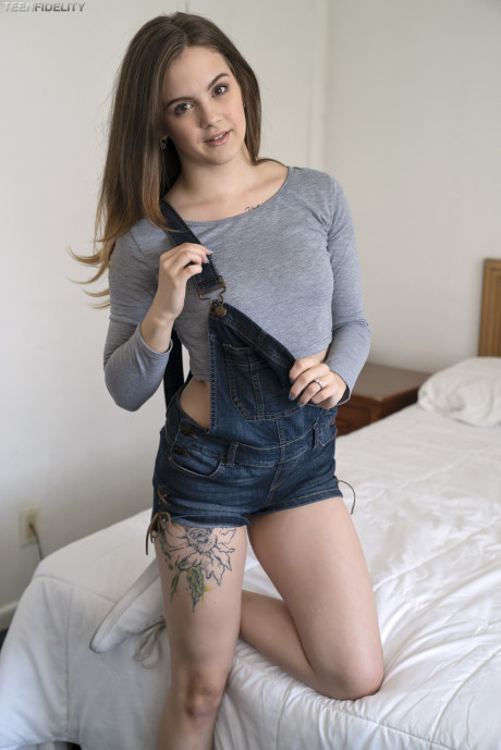 Adorable teen Devon Green pulls off her shorts to show charming ass on the bed