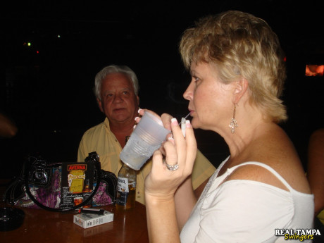 Yellow-haired amateur cougar shows her shaved clam in the swinger night club