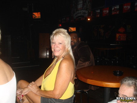 Yellow-haired amateur cougar shows her shaved clam in the swinger night club