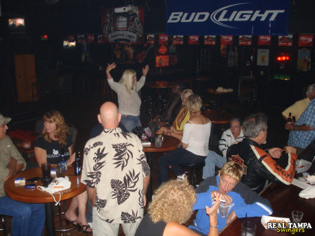 Yellow-haired amateur cougar shows her shaved clam in the swinger night club