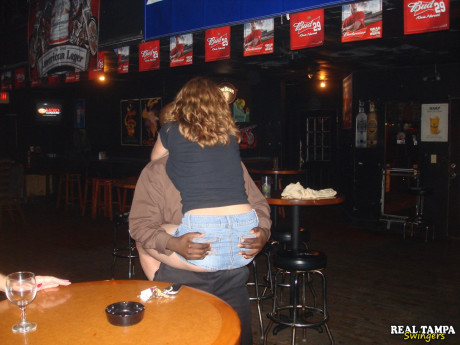 Yellow-haired amateur cougar shows her shaved clam in the swinger night club
