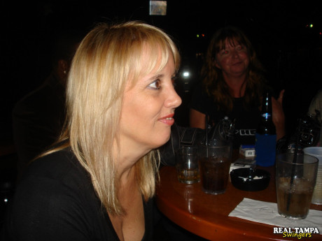 Yellow-haired amateur cougar shows her shaved clam in the swinger night club