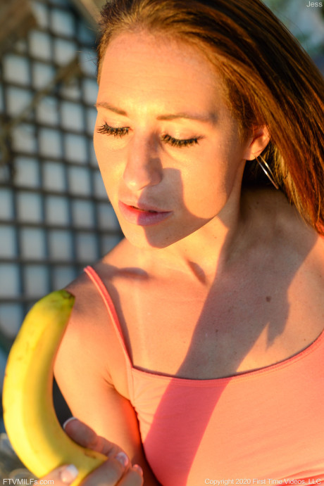 Lusty amateur MILF Jess toys her pussy with a banana on an outdoor bench