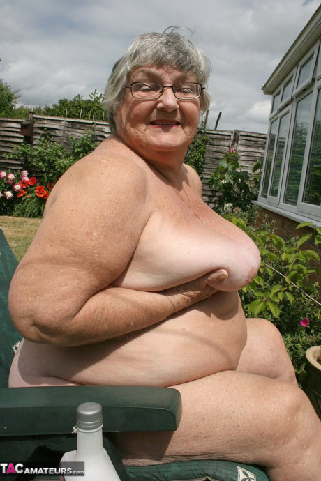 Slutty amateur old lady Libby inserting a bottle in her chunky cunt in the garden