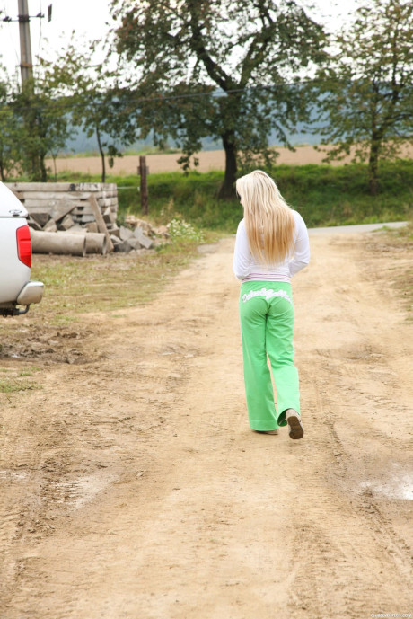 Fresh teen blondie grabs her behind as she peels off sweatpants on a farm truck