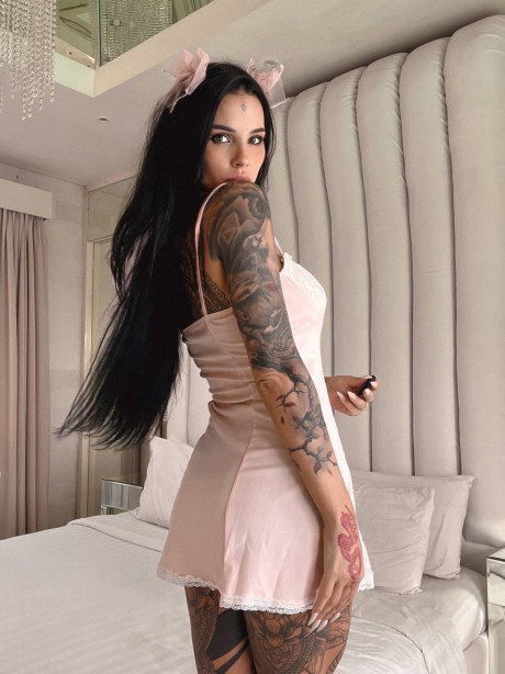Tattooed brunette shows off her large titties & her great behind on her bed