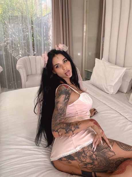 Tattooed brunette shows off her large titties & her great behind on her bed