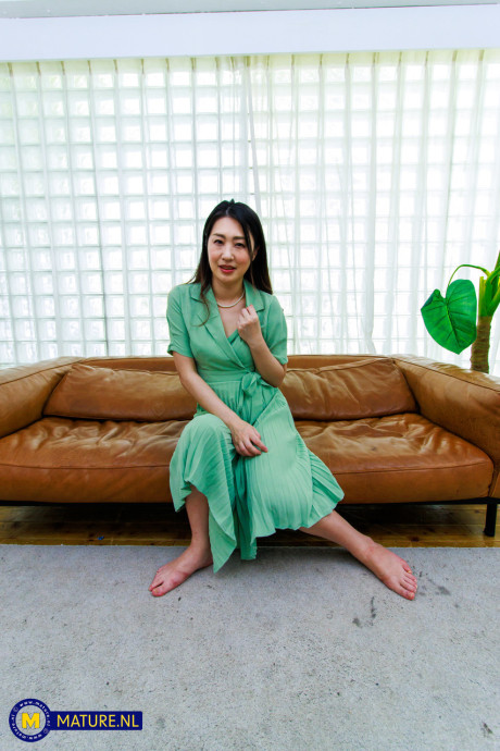 Japanese MILF Megumi Satuki shows her body and poses on a couch