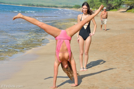 Two slim brunette babes get completely undressed and make out at the beach