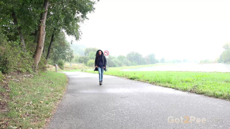 Beautiful dark haired babe pees on the ground