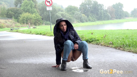 Beautiful dark haired babe pees on the ground