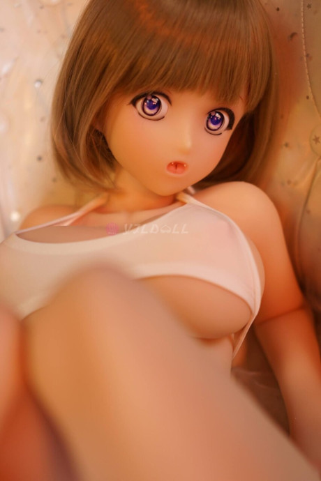 Cute sex doll models on a bed in a thong and micro bikini top