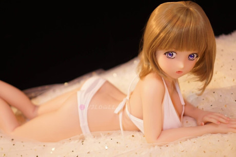 Cute sex doll models on a bed in a thong and micro bikini top