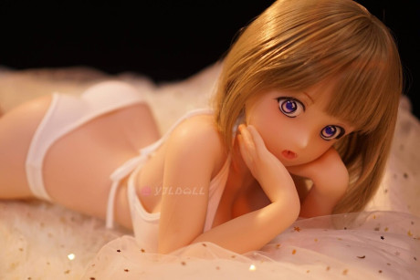 Cute sex doll models on a bed in a thong and micro bikini top
