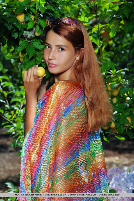 Young young hispanic red hair Agatha Vega removes a poncho to model undressed in a garden