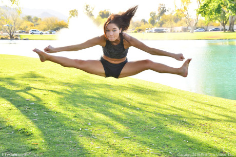 Teenage beauty in charming outfit Zoe doing exercise outdoors by the water