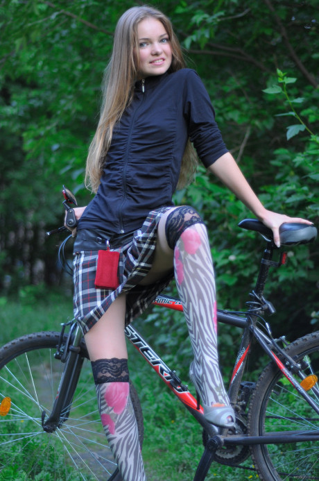 Ravishing teenie babe Bridgit A riding her bicycle pantyless in nature
