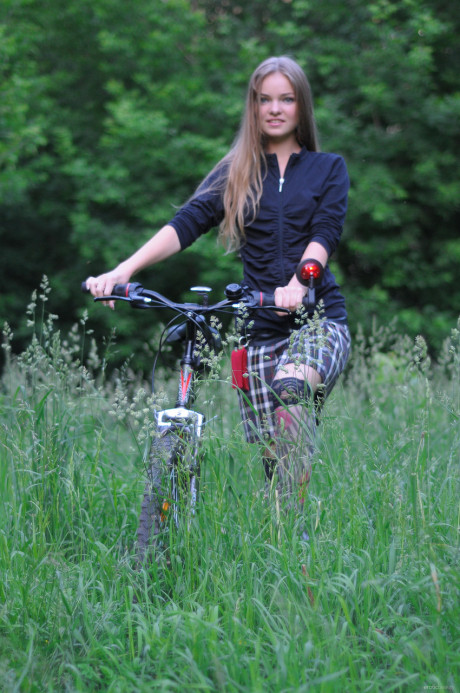 Ravishing teenie babe Bridgit A riding her bicycle pantyless in nature